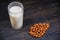 Freshly squeezed veggie drink. Cup of almond milk and nats on a dark wooden background. Almonds and a glass of milk