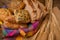 Freshly various buns and bread slices in a basket and a half whole grain bread on a jute fabric