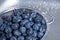 Freshly washed blueberries in a stainless steel colander in a kitchen sink