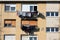 Freshly washed laundry left to dry on warm winter sun on edge of apartment windows of old apartment building