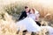 Freshly wed bride and groom posing in wheat field.