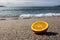 Freshness. Half an orange on the sand against the backdrop of the ocean