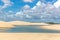 Freshwater lagoons in the middle of a white sand desert, clouds in the sky with green trees in the background