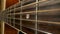 Fretboard of acoustic guitar. Classical guitar strings vibrate when playing a song. Brown wooden guitar neck with