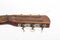 Fretboard with pegs of an old yellow red wooden guitar with strings close-up isolated on a white background