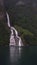 Friaren, also known as The Suitor waterfall and its reflection in the pristine fjord waters, Geirangerfjord, Norway