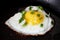Fried appetizing bright yellow egg on a black griddle. Photo food horizontal format