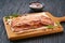 fried bacon strips and bbq sauce on a black table, selective focus