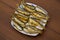 Fried baltic herring on a plate on wooden background