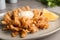 Fried blooming onion with dipping sauce served on table, closeup