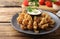 Fried blooming onion with dipping sauce served on wooden table