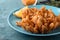 Fried blooming onion served on blue wooden table, closeup