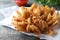 Fried blooming onion served on grey table, closeup