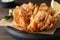 Fried blooming onion served on wooden table, closeup