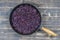 Fried blue cabbage with onion, apple and garlic in frying pan on wooden table. Top view, closeup