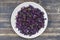 Fried blue cabbage with onion, apple and garlic in plate on wooden table. Top view, closeup