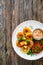 Fried breaded calamari rings with lemon and fresh vegetables on wooden table