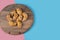 Fried caucasian mutaki cookies on a wooden board on pink blue background