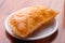 Fried cheburek pie with chopped meat on white plate close-up