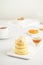 Fried cheese cakes, sweet cheese pancakes on white plate on white background, vertical. Home tea party