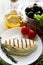 Fried cheese halumi on white plate, olive oil bottle, black olives, tomatoes, healthy food