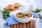 Fried chicken in a creamy garlic sauce or chkmerili chicken in a portioned ceramic pan on a light gray background. Georgian