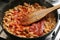 Fried chicken forcemeat with tomato sauce in a pan.