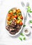 Fried chicken liver and baked seasonal vegetables - delicious healthy lunch on light background