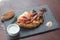 Fried chicken steak with souce and spice on black slate board. Selective focus.