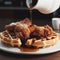 Fried chicken with waffles and syrup. Crispy homemade fried chicken on top of homemade buttermilk waffles with maple syrup