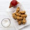 Fried chicken wings with sauce, cold beer on a white wooden table, view from above.