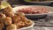 Fried chiken legs on a plate focus in, plate fool of salami focus in on a table