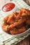 fried coconut shrimp close up in a bowl and tomato sauce. vertical