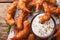 Fried coconut shrimp close-up and a cream sauce on the parchment