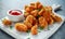 Fried crispy chicken nuggets with ketchup on white board