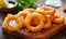 Fried crispy squid rings in tempura. Tasty snack on wooden board, closeup view