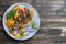 Fried crucian carp with pepper and onion on a plate on a wooden background. Top view