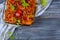 Fried crucian fish in a glass pan on a rustic table