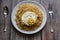 Fried curly noodle with fried egg on top of wooden table ready to be served