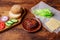 Fried cutlet and different ingredients for a hamburger. Wooden background. Cooking homemade hamburger