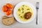 Fried cutlet with mashed potato in plate, pieces of bread, tomatoes, fork on table. Top view