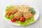 Fried cutlets, lettuce, tomatoes, brown rice, dill in white plat