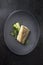 Fried Danish skrei cod fish filet with baby zucchini and lettuce on a modern design plate