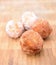 Fried donuts on a wooden plate.