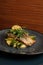 Fried dorado fish and mashed potato on a black plate