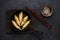 Fried dumplings Gyoza in a frying pan, soy sauce, and chopsticks on a black concrete background