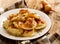 Fried dumplings stuffed with cabbage and meat sprinkled with bacon greaves and chopped parsley on a white plate