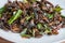 Fried edible insects mix on white plate