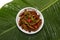 Fried edible insects on white plate and green leaf