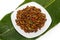 Fried edible insects on white plate and green leaf